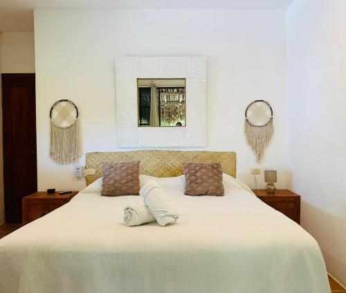 a bedroom with a large white bed with two pillows at Sirenas Caribbean Rooms Holbox in Holbox Island