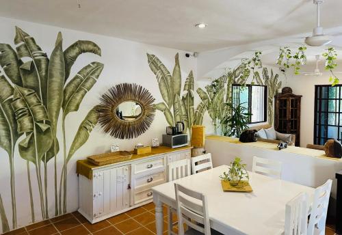 a dining room with a table and some plants on the wall at Sirenas Caribbean Rooms Holbox in Holbox Island