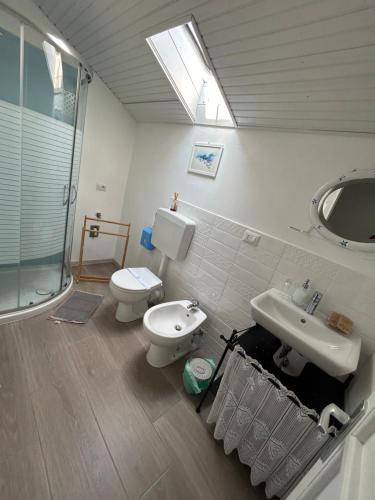 a bathroom with a toilet and a sink and a shower at Acchiappasogni Holiday House in Malgrate