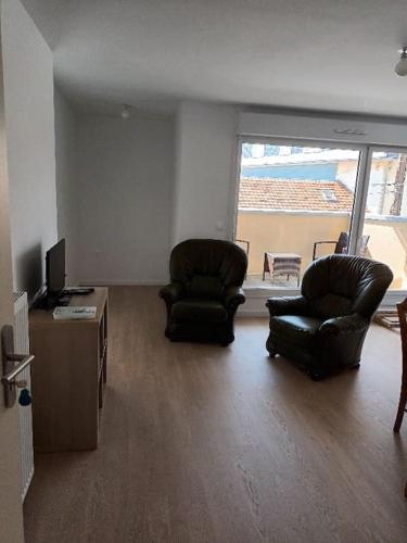 a living room with two chairs and a television at Studio cabine avec terrasse in Fort-Mahon-Plage