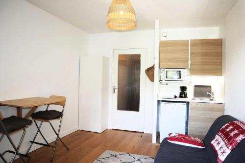 a living room with a table and a kitchen at Résidence Le Boussolenc - JOLI STUDIO CENTRE STATION MAE-2134 in Le Mélézet