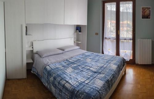 a bedroom with a bed with a blue comforter at Photo House Collodi La Villetta in Collodi