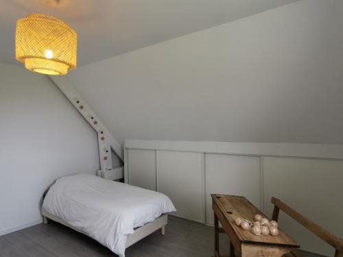 une petite chambre avec un lit et une table dans l'établissement Maison proche Bayeux, à Saint-Martin-des-Entrées