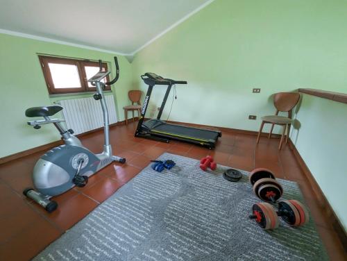 a room with a gym with a treadmill and a rug at Photo House Collodi La Villetta in Collodi