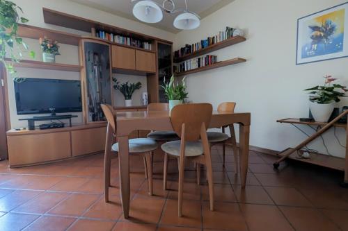 a dining room with a table and chairs and a television at Photo House Collodi La Villetta in Collodi