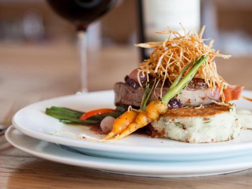a plate of food with meat and vegetables with a glass of wine at NOI Blend Colchagua in Santa Cruz
