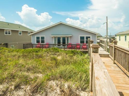 a house on a boardwalk in front of a house at Pelican Perch in Surf City