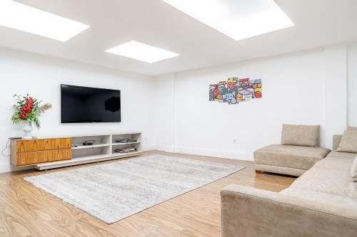 a living room with a couch and a tv at Pousada Areia do Forte in Cabo Frio