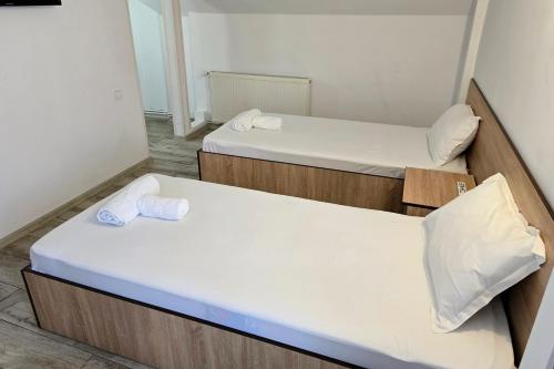 two beds in a small room with white sheets at Flamingo Hotel in Piteşti