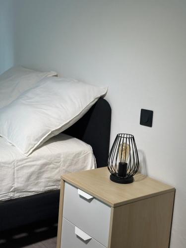 une chambre avec un lit et une table avec une lampe dans l'établissement Jean Kiffer, à Le Plessis-Trévise