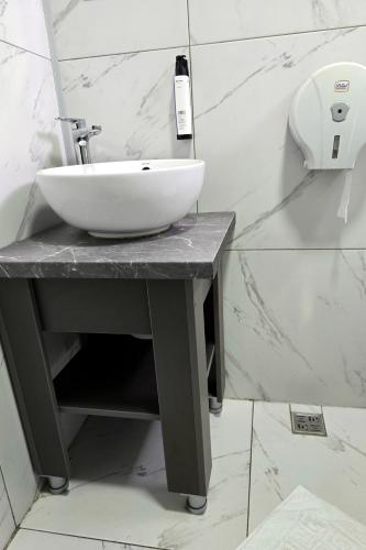 a white sink on a counter in a bathroom at Flamingo Hotel in Piteşti