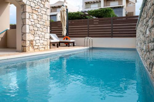 a swimming pool with a bench next to a building at Lydia's Inn 2 - Private pool, near Xylokastro in Melission