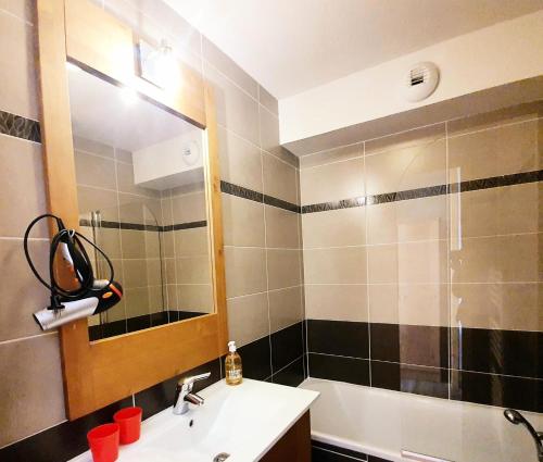 une salle de bain avec un lavabo, un miroir et une baignoire dans l'établissement Les Chalets Des Rennes - Appartement cosy 2 pièces - Les Chalets Des Rennes MAE-9554, à Vars