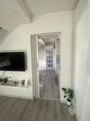 a hallway with a mirror in a white room at Urban Apartment in Sarajevo