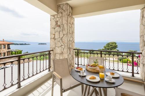 ニキティにあるConstance's House Seaside Villa in Nikitiの海が見えるバルコニーにテーブルと椅子がある