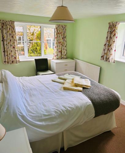 a bedroom with a bed with towels on it at Miller's Cottage in Woolfardisworthy