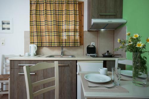 a kitchen with a table with a vase of flowers at Kalami Apartments in Falasarna