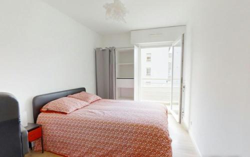 une chambre avec un lit avec des oreillers roses dessus dans l'établissement Apartment T4 Nantes Erdre, à Nantes