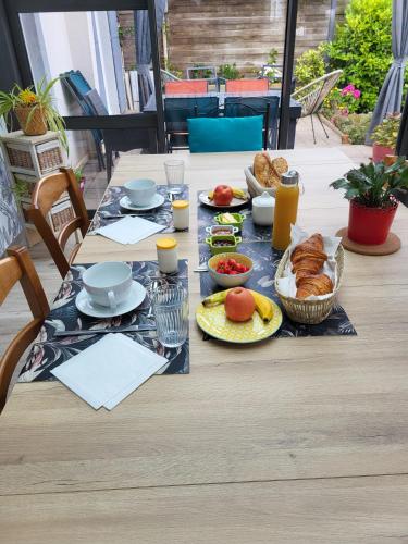 - une table avec petit-déjeuner sur la terrasse dans l'établissement De la mer, à Colleville-Montgomery