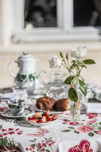a table with a plate of food and a vase with flowers at Château Sénéjac in Le Pian-Médoc