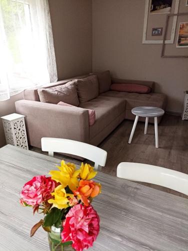 a living room with a table with a vase of flowers at Seosko domaćinstvo Selenić in Rogačica