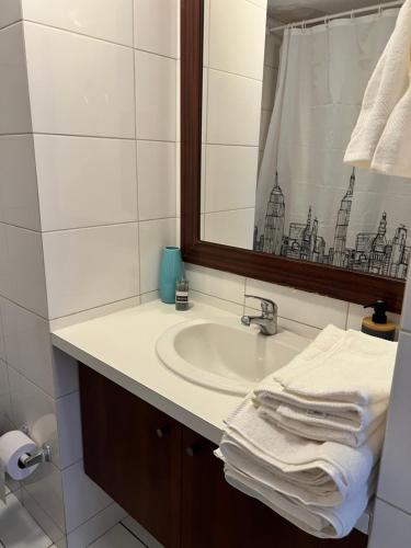 a bathroom with a sink and a mirror and towels at Departamento Céntrico 1 ambiente in Santiago
