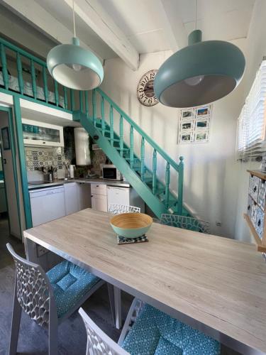 une cuisine avec une table en bois et des escaliers verts dans l'établissement Studio Émeraude -Parking-Clim, au Cap d'Agde