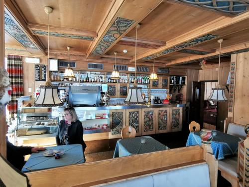 a woman sitting at a table in a restaurant at Hotel la Plaza in Corvara in Badia