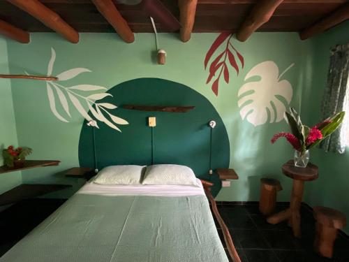 a bedroom with a bed in a green wall at Hotel Entre Dos Aguas in Sámara
