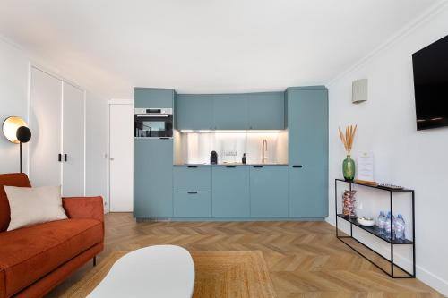 - un salon avec des armoires bleues et un canapé dans l'établissement Appartement Le Marais - 1 Bedroom, à Paris