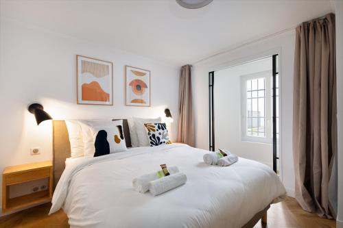 une chambre avec un lit blanc avec des serviettes dessus dans l'établissement Appartement Le Marais - 1 Bedroom, à Paris