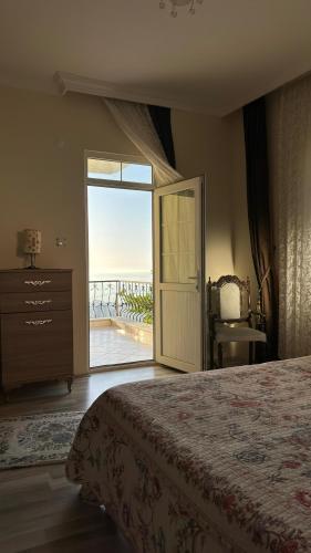 a bedroom with a bed and a door to a balcony at Paradise Villa Trabzon in Trabzon