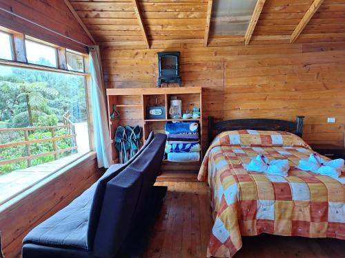 a bedroom with a bed and a window in a cabin at Hotel Mirador de Quetzales in Providencia