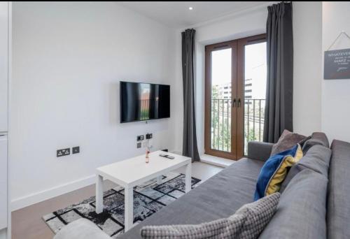 a living room with a couch and a table at Maplewood properties - One bedroom luxurious apartment - Elm in St. Albans