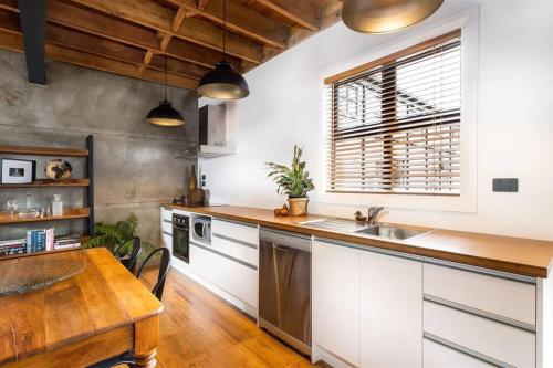a kitchen with a sink and a wooden table at Apartment 4 - Haddin Court - Chic NY Loft Style in Blenheim