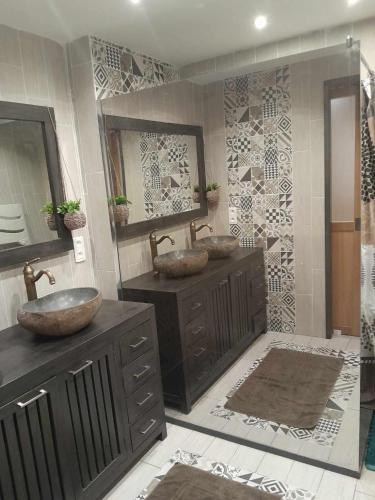 une salle de bain avec deux lavabos et deux miroirs dans l'établissement Maison en pierre rouge du vallon, à Valady