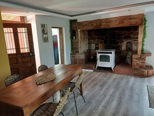 - un salon avec une table en bois et une cheminée dans l'établissement Maison en pierre rouge du vallon, à Valady