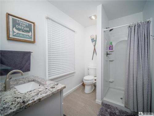 a bathroom with a toilet and a sink and a shower at Casa Andante - Lakefront Escape in Mayville