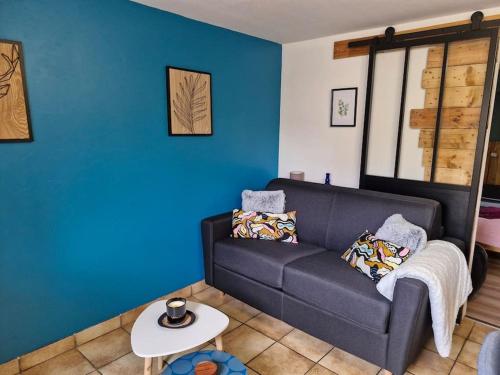 a living room with a couch and a table at La jolie Parenthèse in Longevilles-Mont-dʼOr