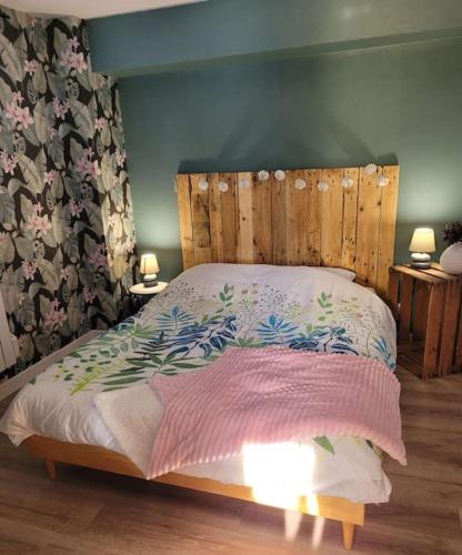 a bed with a wooden headboard in a bedroom at La jolie Parenthèse in Longevilles-Mont-dʼOr