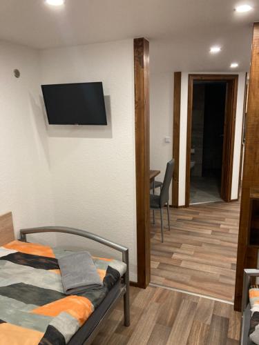 a bedroom with a bed and a flat screen tv on the wall at Ferienwohnung Funke F4 für Monteure in Apolda