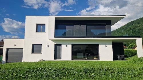 uma casa branca com um relvado verde em Maison moderne em Murianette