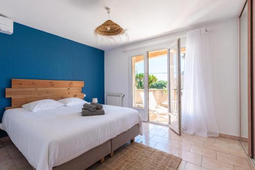 une chambre avec un grand lit avec un mur bleu dans l'établissement Villa Pitou, Piscine chauffée, 200m plage, à La Londe-les-Maures