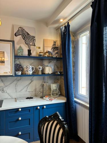 a kitchen with blue cabinets and a window at La Dolce Vita Apartments in the city center with private parking in Pula