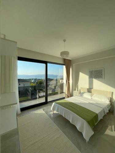 a bedroom with a large bed and a large window at High Garden Villas in Sapanca