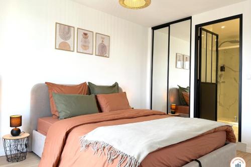 - une chambre dotée d'un lit avec des draps orange et blancs dans l'établissement La Porte de l'Europe - Aperçu mer - Parking, au Havre