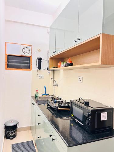 a kitchen with a counter top with a microwave at 1 BHK Fully Furnished - Soorya Madhavam Apartments - Flat No - C2 - Guruvayur, - 150m to North Nada - Family only in Guruvāyūr