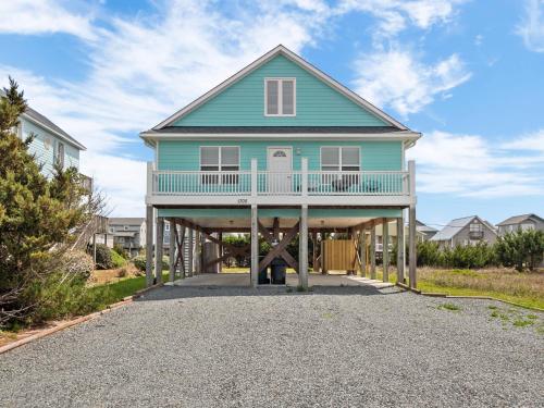 a blue house with a porch on a gravel driveway at Pickens Paradise in Topsail Beach