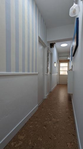 un couloir avec des rayures bleues et blanches sur le mur dans l'établissement Agréable maison bord de mer, à Fouras