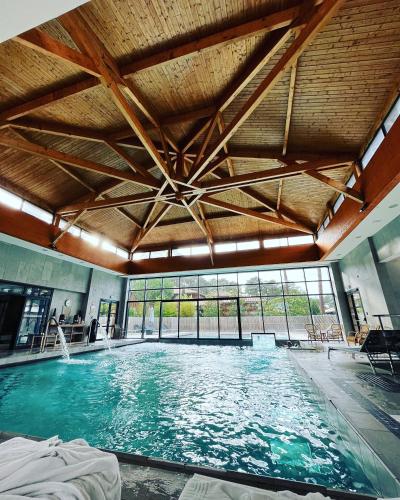 une grande piscine intérieure avec une grande fenêtre dans l'établissement Cabane Claouey, bassin Cap ferret, à Claouey